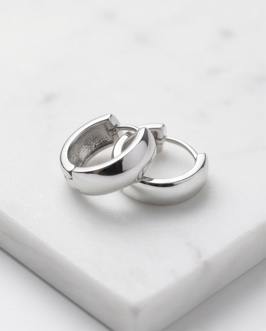Minimalist silver‑tone hoop earrings with a smooth, polished finish