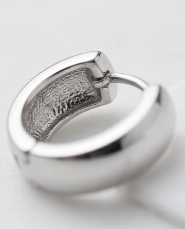 Minimalist silver‑tone hoop earrings with a smooth, polished finish