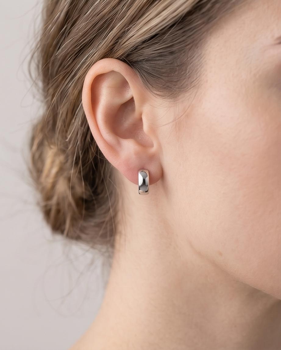 Minimalist silver‑tone hoop earrings with a smooth, polished finish