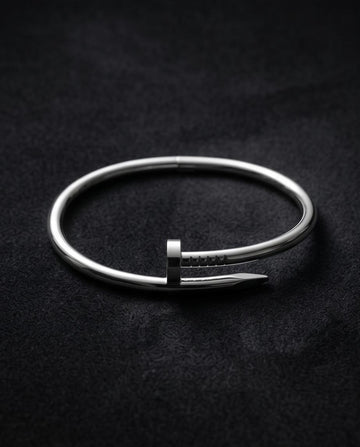 A sleek silver‑tone nail‑inspired bangle