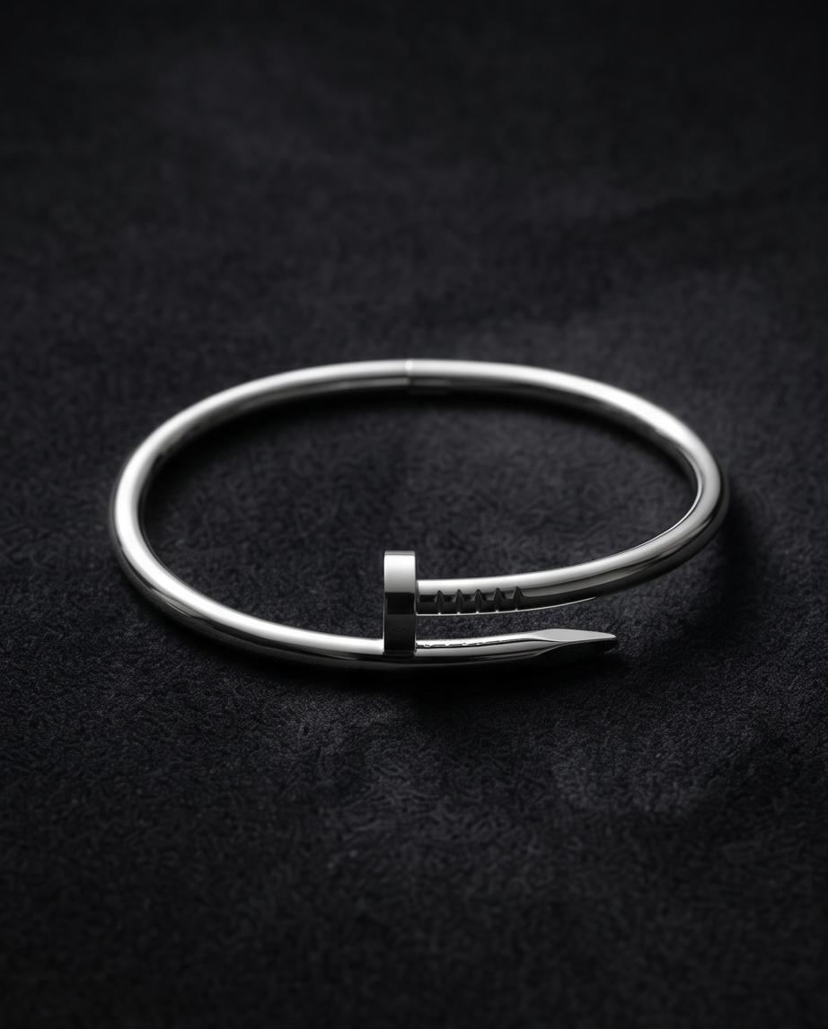 A sleek silver‑tone nail‑inspired bangle