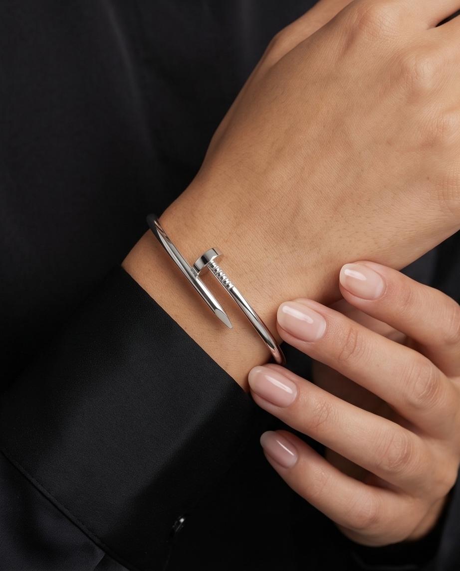A sleek silver‑tone nail‑inspired bangle