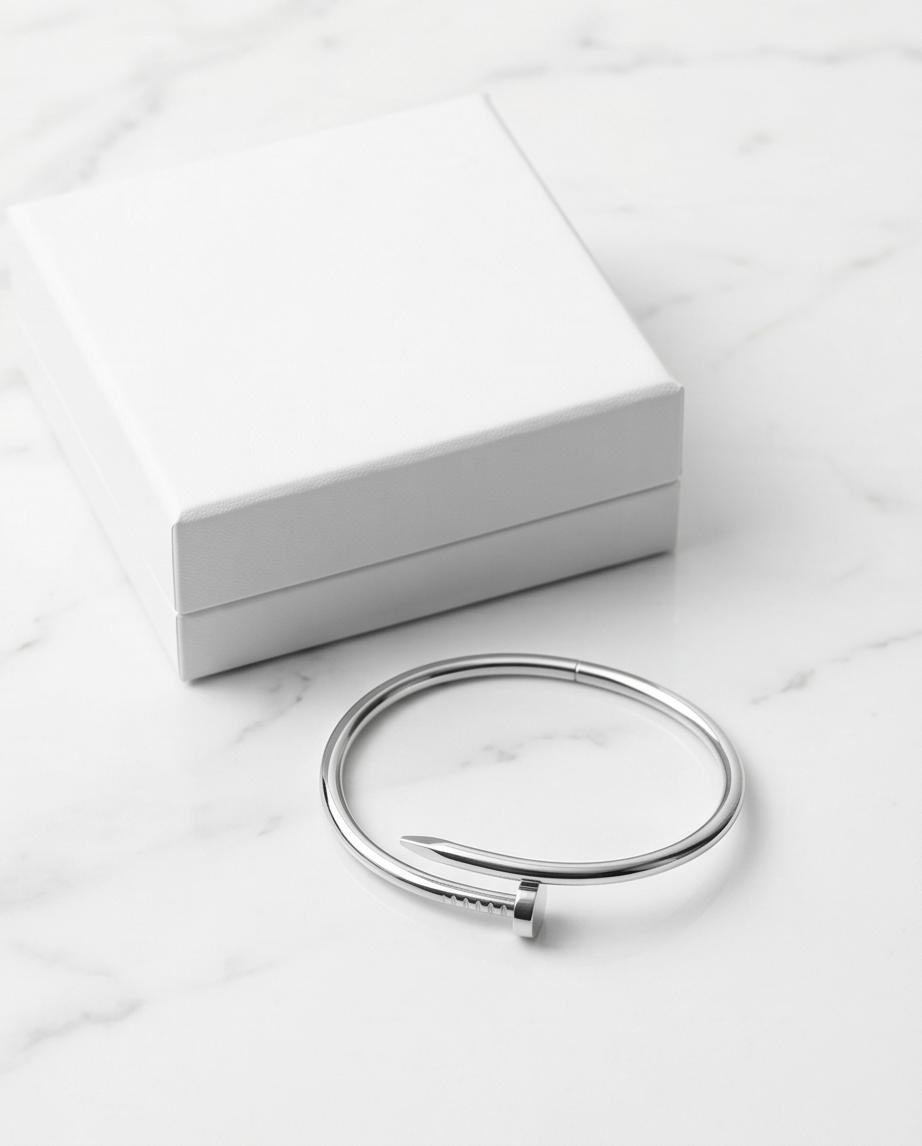 A sleek silver‑tone nail‑inspired bangle