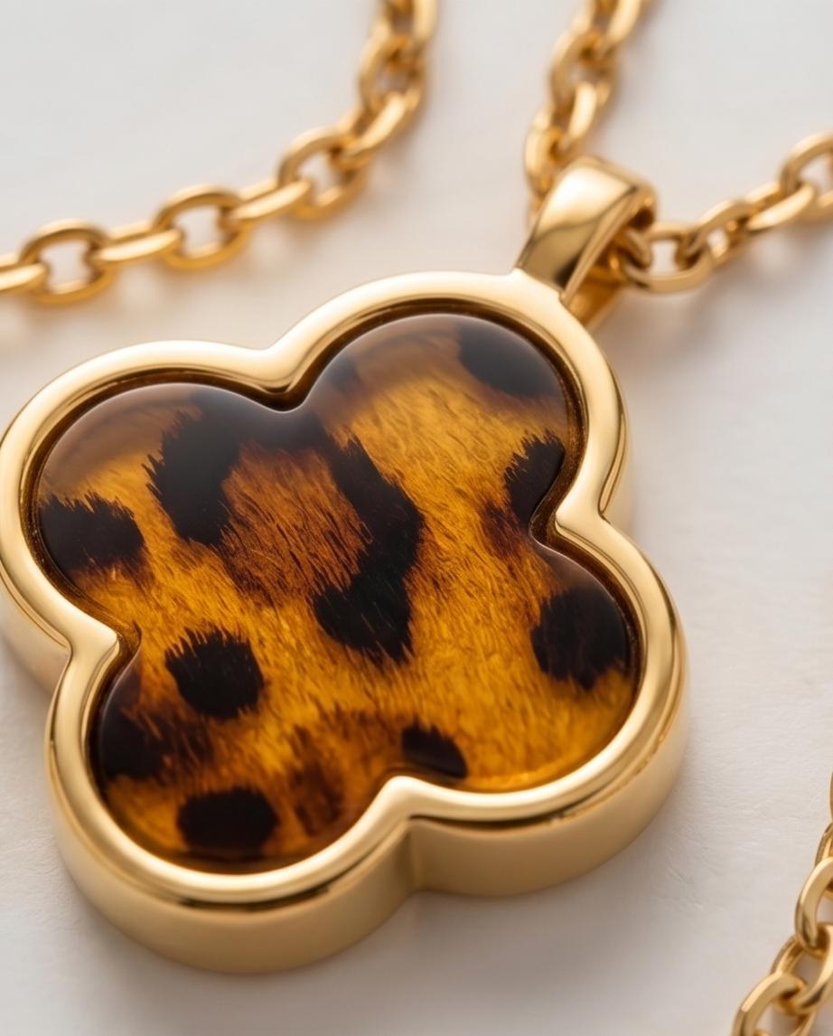 A gold‑tone clover pendant necklace with warm tortoiseshell detail